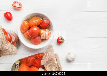 Eingemachtes Gemüse Tomate in Gläsern auf weißem Holzbrett. Blick von oben. Verschiedene Arten von Konserven. Hausgemachte Ernte fallen die Vorbereitungen. Stockfoto