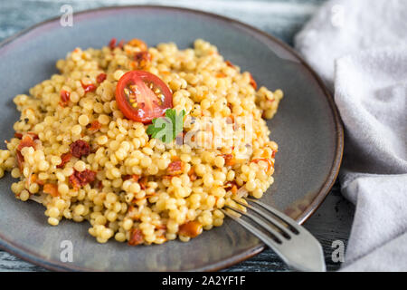 Ptitim oder Birdy, israelische Teigwaren Couscous mit Tomaten und Kräuter/ Stockfoto