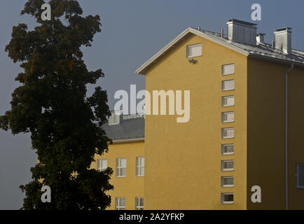 Ein High School Gebäude mit vielen Fenstern in der Zeile. Die Mauer ist verputzt und Gelb lackiert Stockfoto