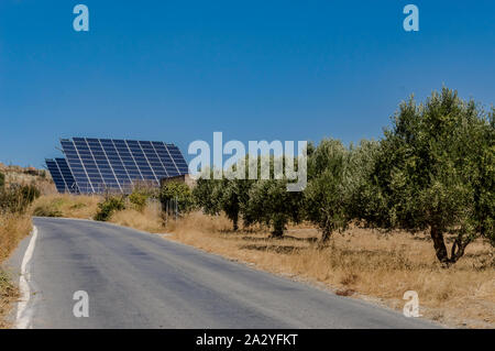 Vier Sonnenkollektoren auf einem Hügel über einem olivenbaum Feld auf der Insel cCrete in Griechenland Stockfoto