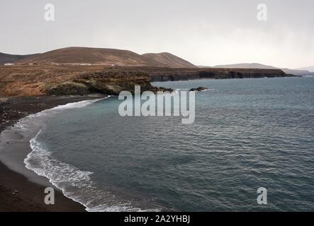 Strand mit schwarzem Sand in der Nähe von felsigen Küste in Ajuy Dorf, Fuerteventura, Spanien. Stockfoto