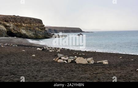 Strand mit schwarzem Sand in der Nähe von felsigen Küste in Ajuy Dorf, Fuerteventura, Spanien. Stockfoto