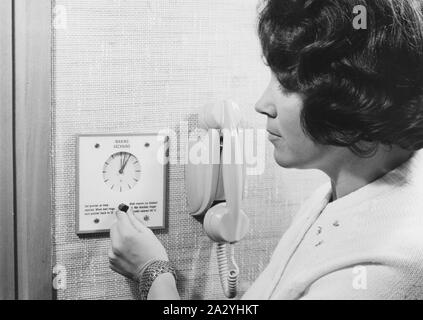 Ein Hotelgast in die Zeit, als sie auf den Alarm auf ihren Weckruf gehen will. 1950 s Stockfoto