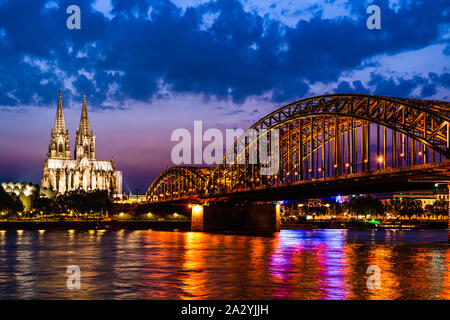 Köln, Deutschland: Schöne Nacht Landschaft des gotischen Dom, Hohenzollernbrücke und Reflexionen über den Rhein mit verschleierten Himmel f Stockfoto