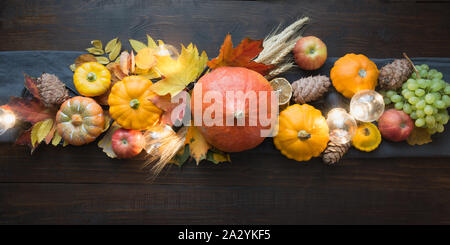 Herbst Dekor für Thanksgiving Day mit Kürbissen, Blätter, Äpfel, Lichter auf Holztisch. Blick von oben. Horizontale Ausrichtung. Mittelstücke danken Stockfoto