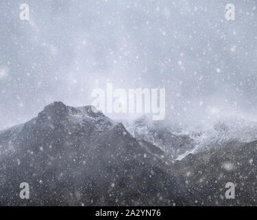 Atemberaubende Moody dramatische Winterlandschaft mountain Bild von schneebedeckten Y Garn in Snowdonia Stockfoto