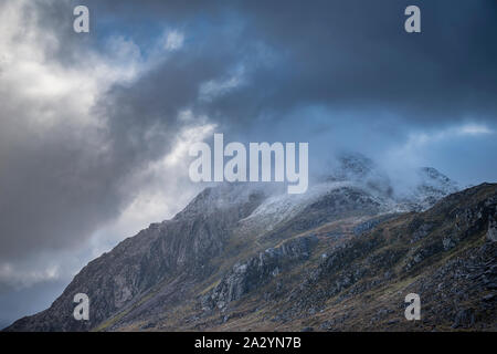 Atemberaubende Moody dramatische Winterlandschaft Bild von schneebedeckten Tryfan Berg in Snowdonia bei stürmischem Wetter Stockfoto