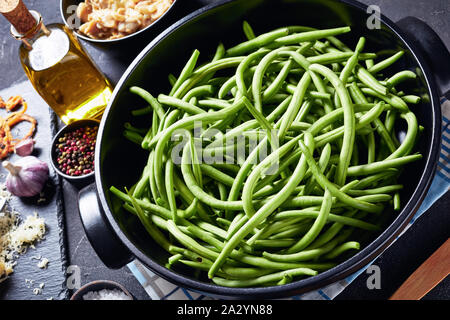 Zutaten für klassische Thanksgiving Kasserolle. frische grüne Bohnen in einer schwarzen Teller, knusprige Pommes Zwiebeln, geriebenem Käse, sautierten Pilzen, Knoblauch Stockfoto