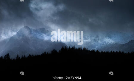 Atemberaubende Moody dramatische Winterlandschaft mountain Bild von schneebedeckten Y Garn in Snowdonia Stockfoto