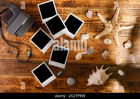 Blick von oben auf die leere Fotografien neben einer Kamera auf einem Holztisch. Das Konzept der angenehme Erinnerungen. Stockfoto