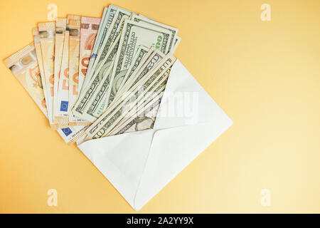 In der Nähe von wunderschönen Dollar und Euro in den Umschlag auf einen gelben Hintergrund. Stockfoto