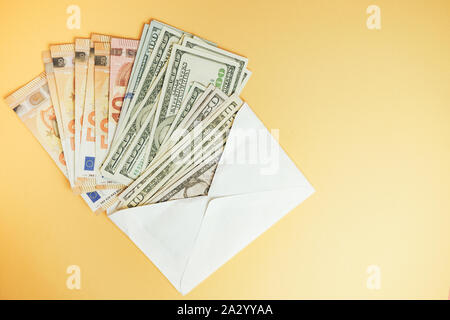 In der Nähe von wunderschönen Dollar und Euro in den Umschlag auf einen gelben Hintergrund. Stockfoto