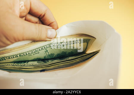 In der Nähe von wunderschönen Dollar in der Umschlag auf einem gelben Hintergrund. American, US-Dollar Bargeld. Hundert Dollar Banknoten. Stockfoto