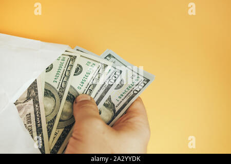 In der Nähe von wunderschönen Dollar in der Umschlag auf einem gelben Hintergrund. American, US-Dollar Bargeld. Hundert Dollar Banknoten. Stockfoto