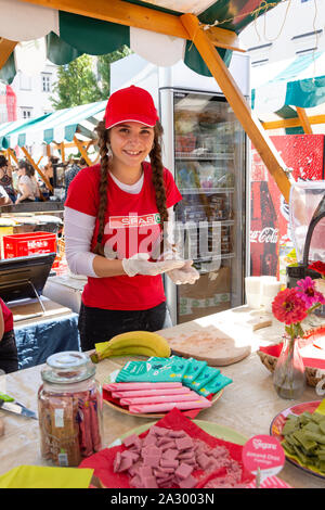 Junge Frau in Vegetarische arbeiten Abschaltdruck am Vegafest (veganes Essen Festival), Pogacarjev Trg, Altstadt, Ljubljana, Sloven Stockfoto