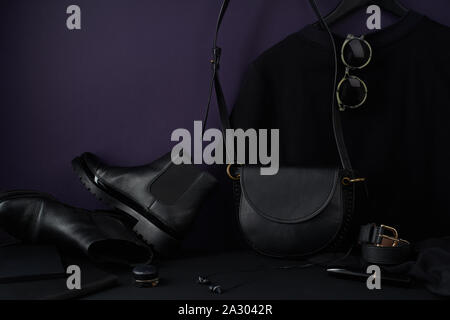 Mode Accessoires, Chelsea Boots, Ledertasche und t-shirt-Kleid in dunklen angeordnet - noch farbige Leben Zusammensetzung Stockfoto