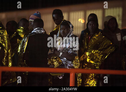 Malaga, Spanien. 04 Okt, 2019. Migranten auf ein Rettungsboot mit Not Thermodecke bedeckt nach Ihrer Ankunft im Hafen von Málaga in Spanien Maritime Rescue Service Insgesamt 64 Migranten an Bord ein beiboot der Alboran See gerettet und brachte sie nach Malaga Hafen, wo sie durch das Spanische Rote Kreuz unterstützt wurden. Credit: SOPA Images Limited/Alamy leben Nachrichten Stockfoto