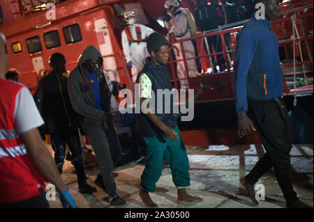 Malaga, Spanien. 04 Okt, 2019. Migranten Aussteigen aus einem Rettungsboot nach Ihrer Ankunft im Hafen von Málaga in Spanien Maritime Rescue Service Insgesamt 64 Migranten an Bord ein beiboot der Alboran See gerettet und brachte sie nach Malaga Hafen, wo sie durch das Spanische Rote Kreuz unterstützt wurden. Credit: SOPA Images Limited/Alamy leben Nachrichten Stockfoto