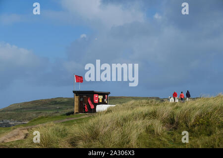 Eine rote RNLI Lifeguards Warnung Fahne über den Strand fliegen an Godrevy in Cornwall. Stockfoto