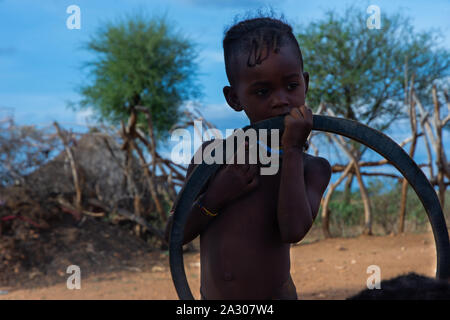 Turmi, Äthiopien - Nov 2018: Junge Hamer Stamm Kid spielen mit reifen, Omo Valley Stockfoto