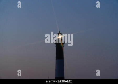 Fire Island Lighthouse beacon Cross star Wirkung von Rundumleuchte über Robert Moses Strand bei Nacht leuchtenden Signalisierung Shoreline zu Ocean Boote tra Stockfoto