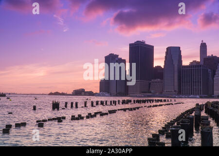 Schöne Sicht auf Downtown Manhattan Skyline Financial District als sun goes down in majestätischen Sonnenuntergang hinter Stadt lila Farbe über Abendhimmel Stockfoto