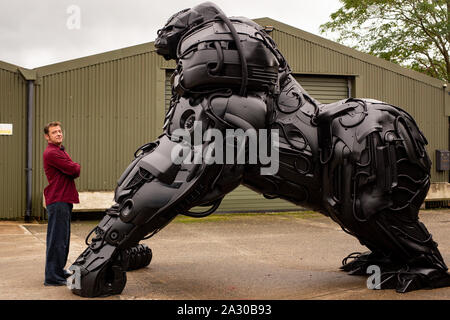 Bildhauer Lukas Drachen mit seinen 12 ft Skulptur eines Gorilla Gorilla, "Apokalypse", vollständig aus Schrott Stoßstangen und Panels nur aus den letzten zehn Jahren verworfen erstellt, auf der die britische Schmiedearbeiten Zentrum in Telford, Shropshire. Stockfoto