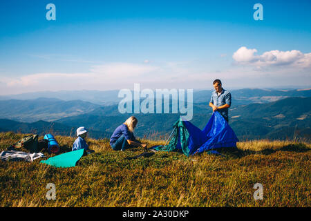 Familie Blick auf die schöne Welt. Eltern und Sohn Entspannen in der Nähe von Zelt auf dem Campingplatz Urlaub Stockfoto