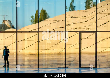 Reflexion der ein Mann stand in der Nähe von einem der Eingänge des Heydar Aliyev Center, Baku, Aserbaidschan Stockfoto