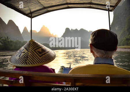 Active Senior touristische Paar schönen Sonnenuntergang hinter Li River basin Berge, Guangxi, China Stockfoto