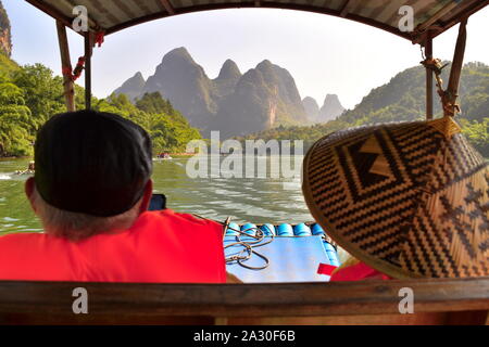 Senior touristische Paar genießen Li River schönen grünen Berggipfel von bambusfloß Schiffsfahrt, Guangxi, China Stockfoto