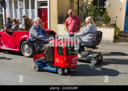 Mann auf Mobilität scooter gebildet, um wie ein Lastwagen hält für einen Chat in des Bischofs Schloss Michaelmas Fair, Shropshire, England, UK suchen Stockfoto