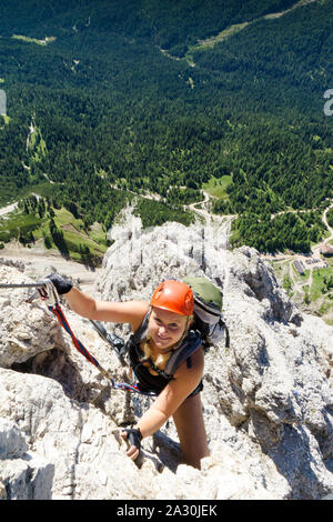 Attraktive Blondine weiblichen Bergsteiger auf einem steilen Klettersteig in Südtirol Stockfoto