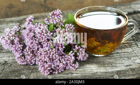 Wild origanum flower Tee oder Auskochen, Majoran Knospen auf alten Texturierte rustikalen Holzmöbeln Hintergrund, Nahaufnahme, Kopie, alternative Medizin und naturopat Stockfoto