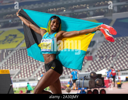 Doha, Katar. 4. Okt 2019. Shaunae Miller-Uibo von Bahamas feiert, während eine Flagge während der Frauen 400 m - IAAF Leichtathletik WM bei Khalifa International Stadium in Doha. Credit: SOPA Images Limited/Alamy leben Nachrichten Stockfoto