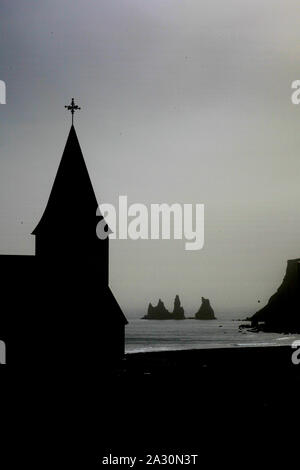 Der Vik-Kirche liegt auf einem Hügel im Dorf, und alle Dorfbewohner sind in den Kindergarten neben der Kirche bei einer Eruption des Katla Vulkan zu Bericht Stockfoto