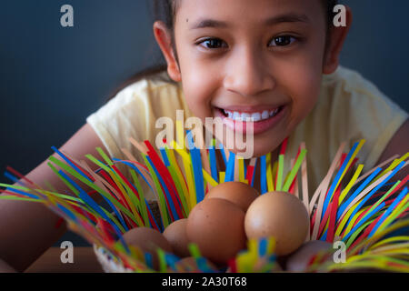 Close up cute asiatische Mädchen lächelnd mit Huhn Eier in einem Korb, Ostern Konzept. Stockfoto