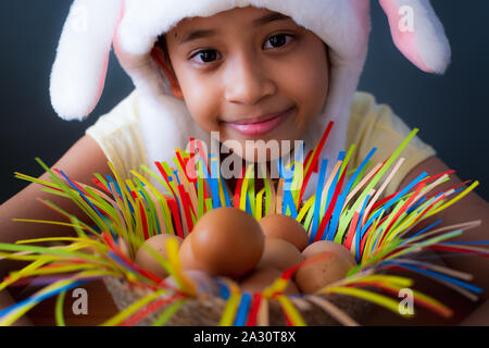 Frohe Ostern! Close up nettes Mädchen tragen Kaninchen hat mit Huhn Eier in einem Korb, Ostern Urlaub Konzept. Stockfoto