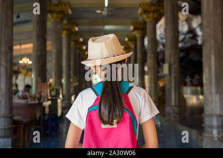 Mädchen mit Rucksack eingabe Tempel in Wat Tham Seua (Tham Seua Tempel), Krabi, Thailand zu Buddhistischen. Stockfoto