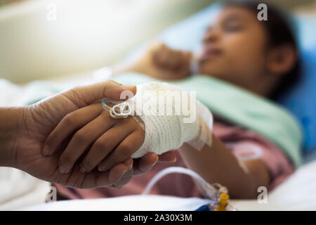 Die Mutter von Hand die Hand ihrer Tochter im Krankenhaus. Gesundheitswesen und Medizinische Konzept. Stockfoto