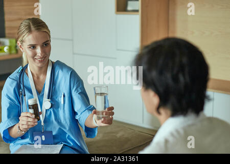 Schöne lächelnde Frau der Arzt in einer Flasche Pille bietet den Patienten. Stockfoto