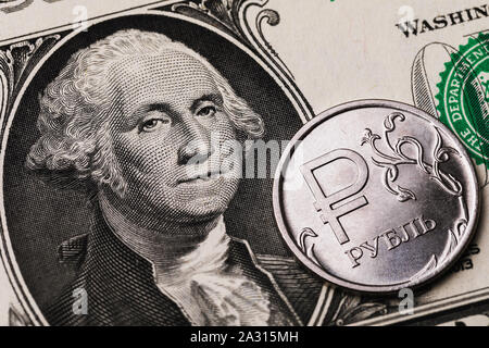 1 Rubel Münze vor dem Hintergrund von 1 Dollar Bill, close-up. Auf der Münze ist die Inschrift in russischen Buchstaben Rubel Stockfoto