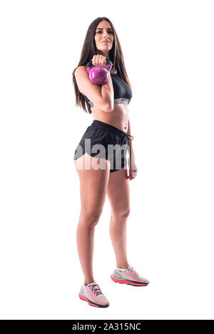 Stolz, selbstbewussten jungen fitness Frau posiert Während kettlebell. Voller Körper auf weißem Hintergrund. Stockfoto