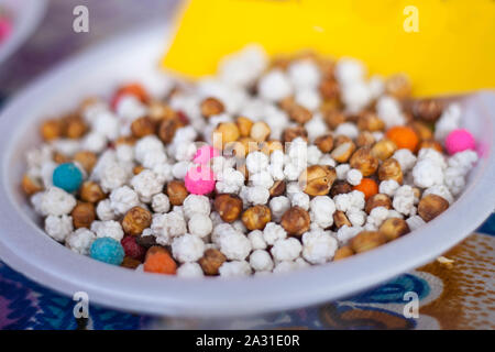 Bunt mit Zucker überzogene gebratene Kichererbsen, traditionelle Nüsse, runde kleine Süßwaren. Stockfoto