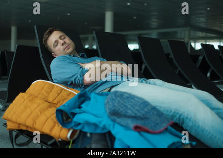Reifer Mann im Flughafen schlafen auf einer Werkbank Stockfoto
