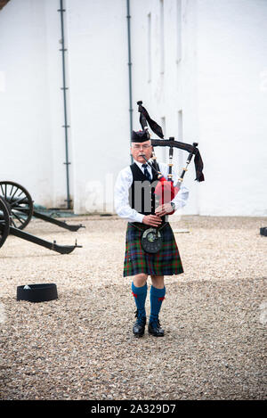 Traditionell Schotte mit Dudelsack an Blair Castle, dem Stammsitz der Herzöge und Grafen von Atholl gekleidet. Die Burg ist 740 Jahre alt. Stockfoto