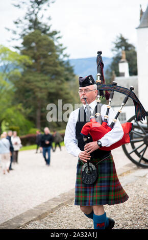 Traditionell Schotte mit Dudelsack an Blair Castle, dem Stammsitz der Herzöge und Grafen von Atholl gekleidet. Die Burg ist 740 Jahre alt. Stockfoto