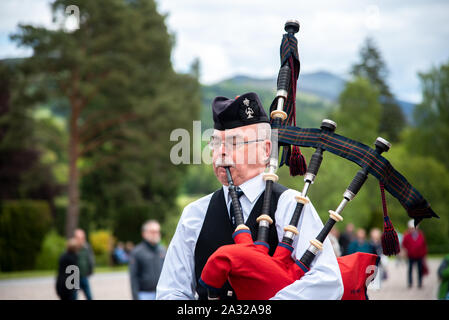 Traditionell Schotte mit Dudelsack an Blair Castle, dem Stammsitz der Herzöge und Grafen von Atholl gekleidet. Die Burg ist 740 Jahre alt. Stockfoto