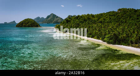 Antenne Aussicht auf Las Cabanas Sandstrand mit Kokospalmen in El Nido, Palawan, Philippinen Stockfoto