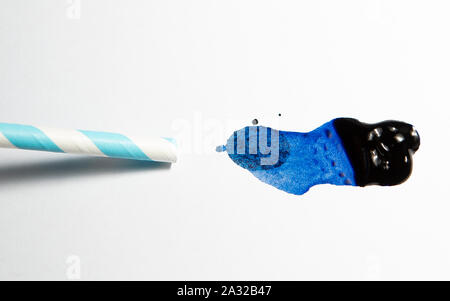 Blaue Tinte von einem Stroh auf weißem Papier geblasen Stockfoto